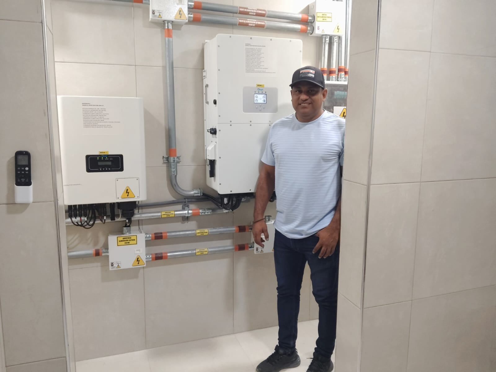 Ingeniero de AS Solar Energy junto a inversores instalados